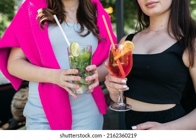 Girl Holding Cocktails In Her Hands Girl Holding Aperol And Mojito In Her Hands. Summer Time. Heat.