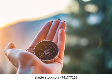 Girl Holding A Compas In A Hand On The Carpathian Mountains Background During The Sunset