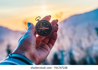 Girl Holding A Compas In A Hand On The Carpathian Mountains Background During The Sunset