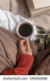 A Girl Holding A Cup Of Black Coffee On A Bed. Aesthetic, Warm Concept