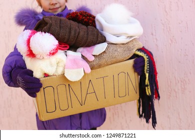 Girl Holding Donation Box With Warm Winter Clothes. 