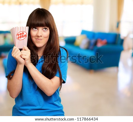 girl holding empty popcorn packet, indoor