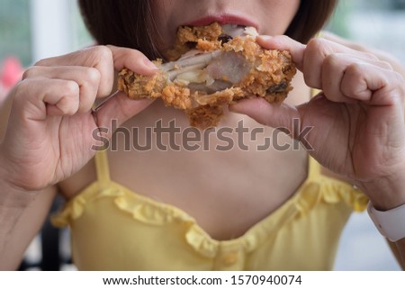 Girl holding fried chicken drumstick for eat, fast food, junk food ,fat concep