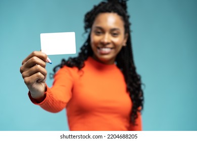 Girl holding a gift card. Young beautiful woman showing copy space on empty blank sign or gift card isolated on blue background