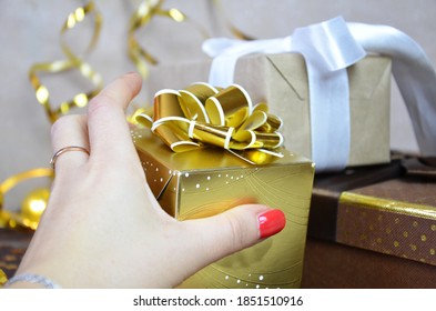 girl holding a gift in her hand many boxes over gray background Christmas gifts snowflakes and gifts, golden serpentine, stars, celebrate the holiday, party. Happy New Year or birthday party - Shutterstock ID 1851510916