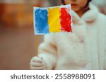 

Girl Holding a Hand Painted Flag Celebrating Romania in Winter. Romanian child feeling patriotic during national holiday 
