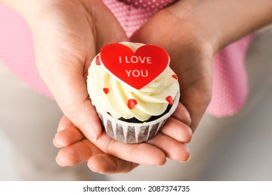 Girl holding heart shaped cake with the inscription I Love You. Cupcake in the shape of Heart, close up - Powered by Shutterstock