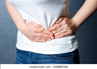 Girl holding her belly, front view, concept of acute pain