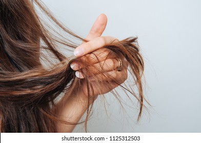 Girl holding her hair in her hand. Hair care concept. Shampoo. Haircut needed. 