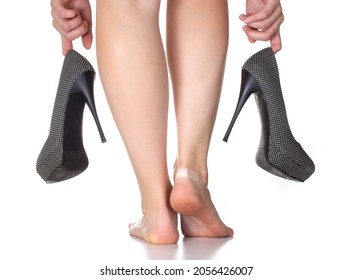 Girl holding high heel shoes on a white background. The concept of uncomfortable shoes and rubbing calluses