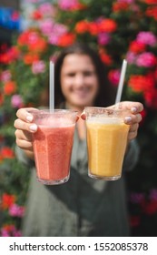 A Girl Holding A Mango And A Stawberry Smoothie. 