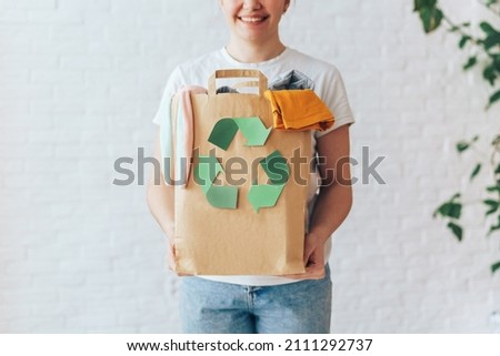 Girl holding paper bag with old clothes for recycling. Foto stock © 
