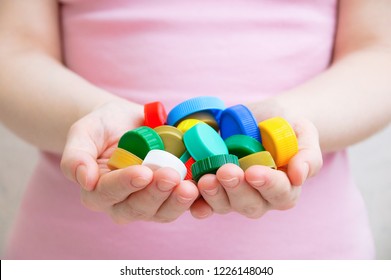 The Girl Is Holding A Plastic Cap. Close-up.