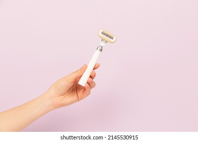 girl holding razor in hand on pink background - Shutterstock ID 2145530915