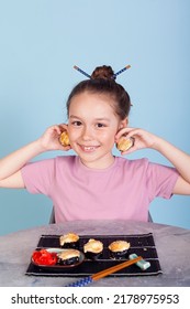 The Girl Holding Rolls Have A Face Like Binoculars. Japanese Cuisine Home Delivery. On A White Background In An Orange Dress. Long Curly Hair. It Is Ridiculous And Stupid.