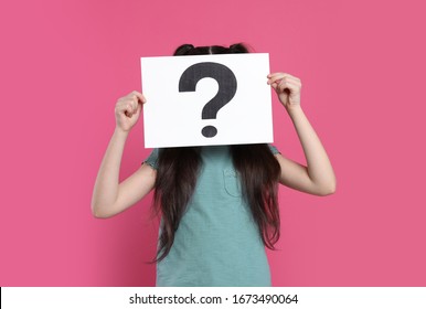 Girl holding sheet of paper with question mark on pink background