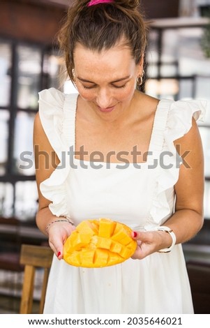 girl holding a sliced mango in her hand, vegetarian 