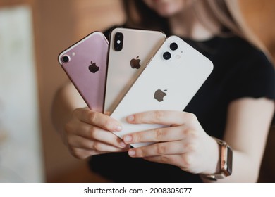 Girl Holding A Smartphone Apple Iphone 12 White, Apple Iphone Xs Gold And Apple Iphone 8 Pink In Her Hand On The Day Of Purchase. Omsk, Russia  18 June 2021. 