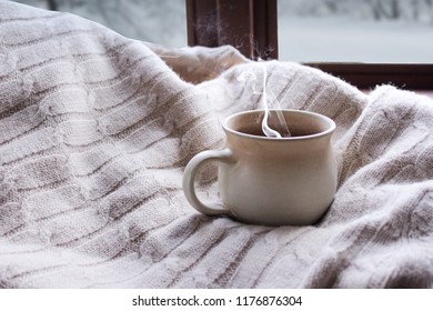 Girl Holding A Smoking Mug In Winter In Front Of A Window