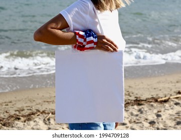 Girl Is Holding Tote Bag Canvas Fabric For Mockup Blank Template Isolated On Beach And Sea Background.