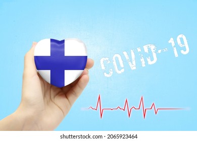 A Girl Is Holding A Toy In The Shape Of A Heart With The Flag Of Finland, A Concept Of Health Care During The Covid-19 Coronavirus Pandemic