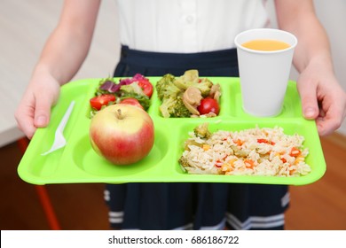 Girl Holding Tray With Delicious Food In School Canteen, Closeup