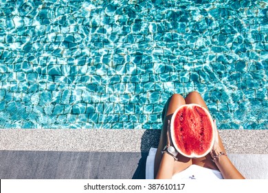 Girl Holding Watermelon In The Blue Pool, Slim Legs, Instagram Style. Tropical Fruit Diet. Summer Holiday Idyllic.