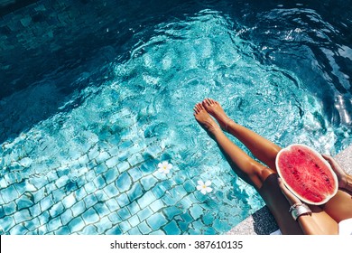 Girl Holding Watermelon In The Blue Pool, Slim Legs, Instagram Style. Tropical Fruit Diet. Summer Holiday Idyllic.