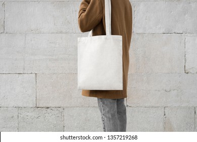 Girl Holding White Cotton Tote Bag On Cement Background 