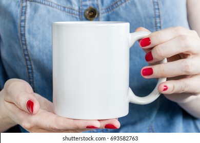 Girl is holding white cup, mug in hands. Mockup for products presentations.