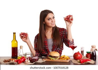 A girl, holds in both hands the two halves of a juicy ripe pomegranate and smiles. Isolated on white.