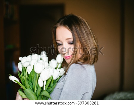 A girl holds a bouquet of white tulips
