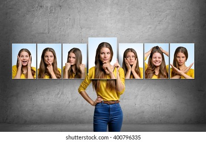 Girl holds and changes her face portraits with different emotions - Shutterstock ID 400796335