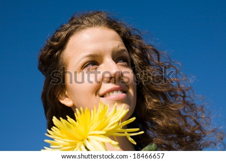 The girl holds a chrysanthemum in a hand