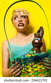 Girl Holds Easter Basket After Taking Bite Of Chocolate Bunny