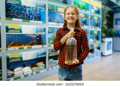 Girl Holds Goldfish And Makes A Wish, Pet Store