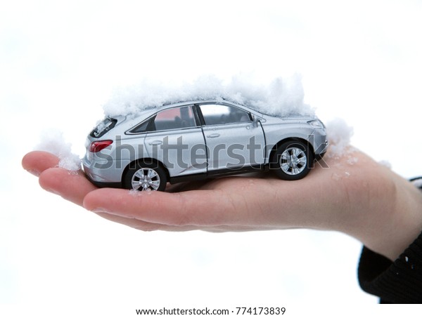 girl\
holds in her hand model of car with snow\
closeup