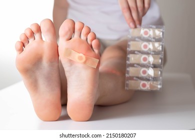 The Girl Holds In Her Hand A Set Of Medical Plasters For Plantar Warts. Treatment Of Calluses On The Feet, Virus