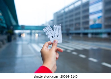 The girl holds in her hand two tickets for the bus traveling from the airport to the city. Krakow, Poland - 05.15.2019