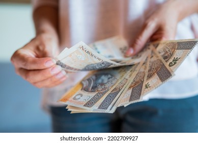 the girl holds in her hands banknotes money polish zlotys and pennies coins salary for payment - Shutterstock ID 2202709927
