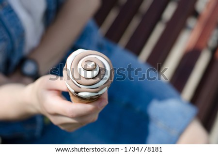 Girl holds ice cream in her hands. Two-color ice cream close-up.