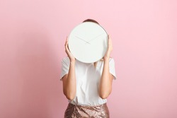 Girl Holds A Mechanical Clock On A Colored Background