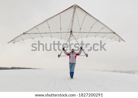Girl holds an old hang glider wing. Dream of flying concept. 