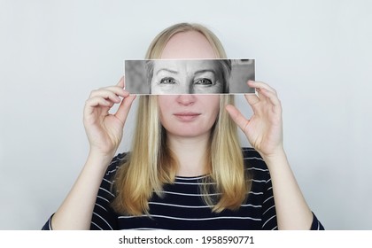 The Girl Holds A Photograph Of Her Old Mother To Her Face. Aging, Genetics, Family Tree And Loss Of Youth Concept. Before And After Age-related Changes. Vintage Photographs