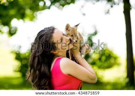 girl holds a small fox. Young woman holding fennec fox in her hands
