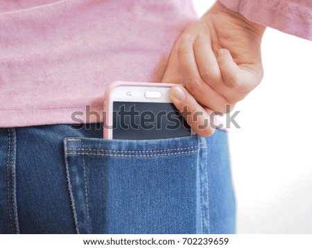 A girl holds a smart phone  from the back pocket.
