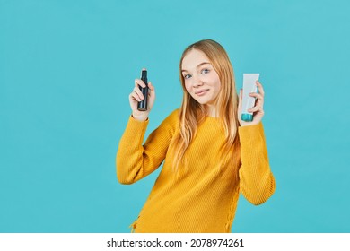 Girl holds tube with cosmetic cream. Teen holding tube of moisturizer, oil, wellness, exfoliator in hand.