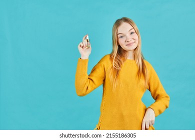 Girl holds tube with cosmetic cream. Teen holding tube of moisturizer, oil, wellness, exfoliator, peeling cream in hand.