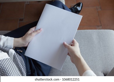 The Girl Holds The White Magazine In Hand