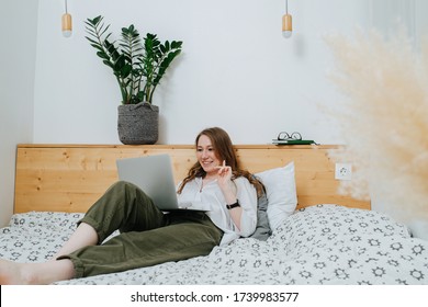 Girl At Home Lying On A Bed With A Laptop Communicates By Video Link 